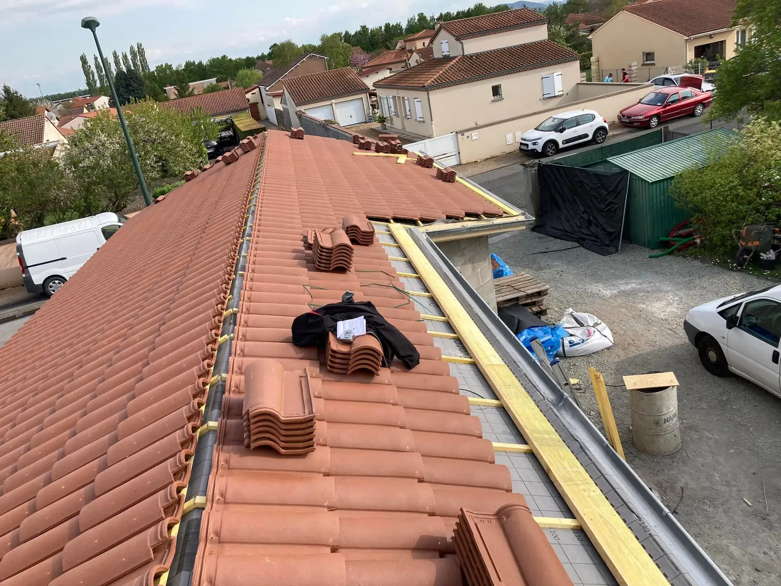 Pose de tuiles neuves le long d’une rive en zinc, au-dessus d’une cour