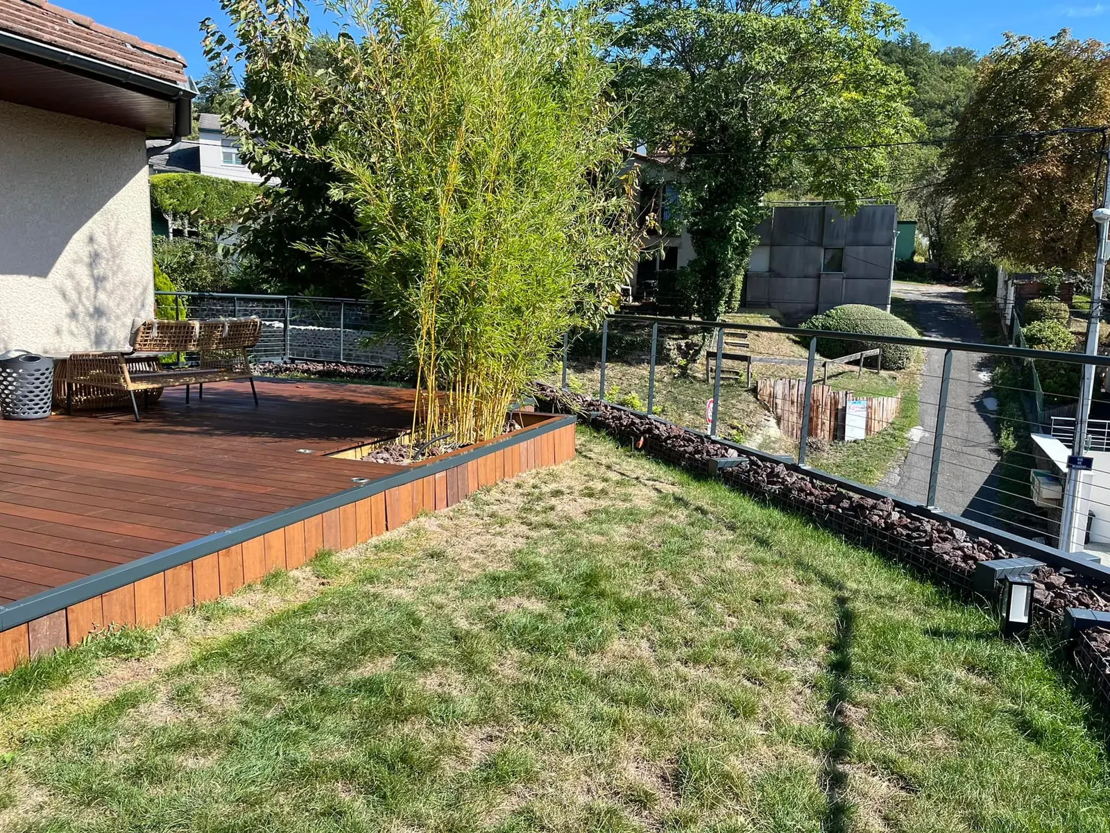 Terrasse en bois au bord d’un jardin planté de bambous